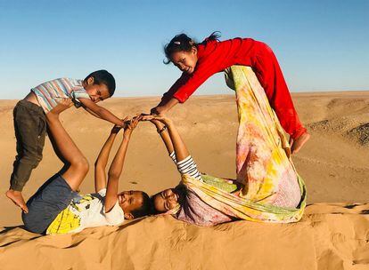 Nana (a la derecha, vestida de color amarillo) juega con otros niños en el Sáhara.