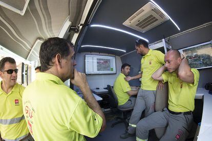 Miembros del Grupo de Emergencias de Andalucía (GREA), en el interior del vehículo donde analizan la situación.