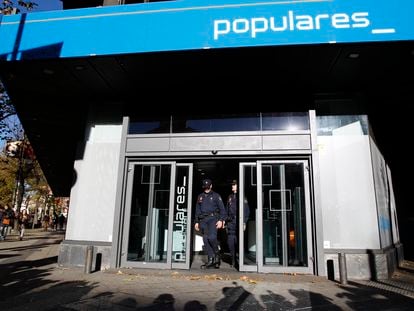Agentes la Policía Nacional, en la puerta de la sede del PP en la calle Génova, de Madrid, durante el registro realizado en diciembre de 2013.