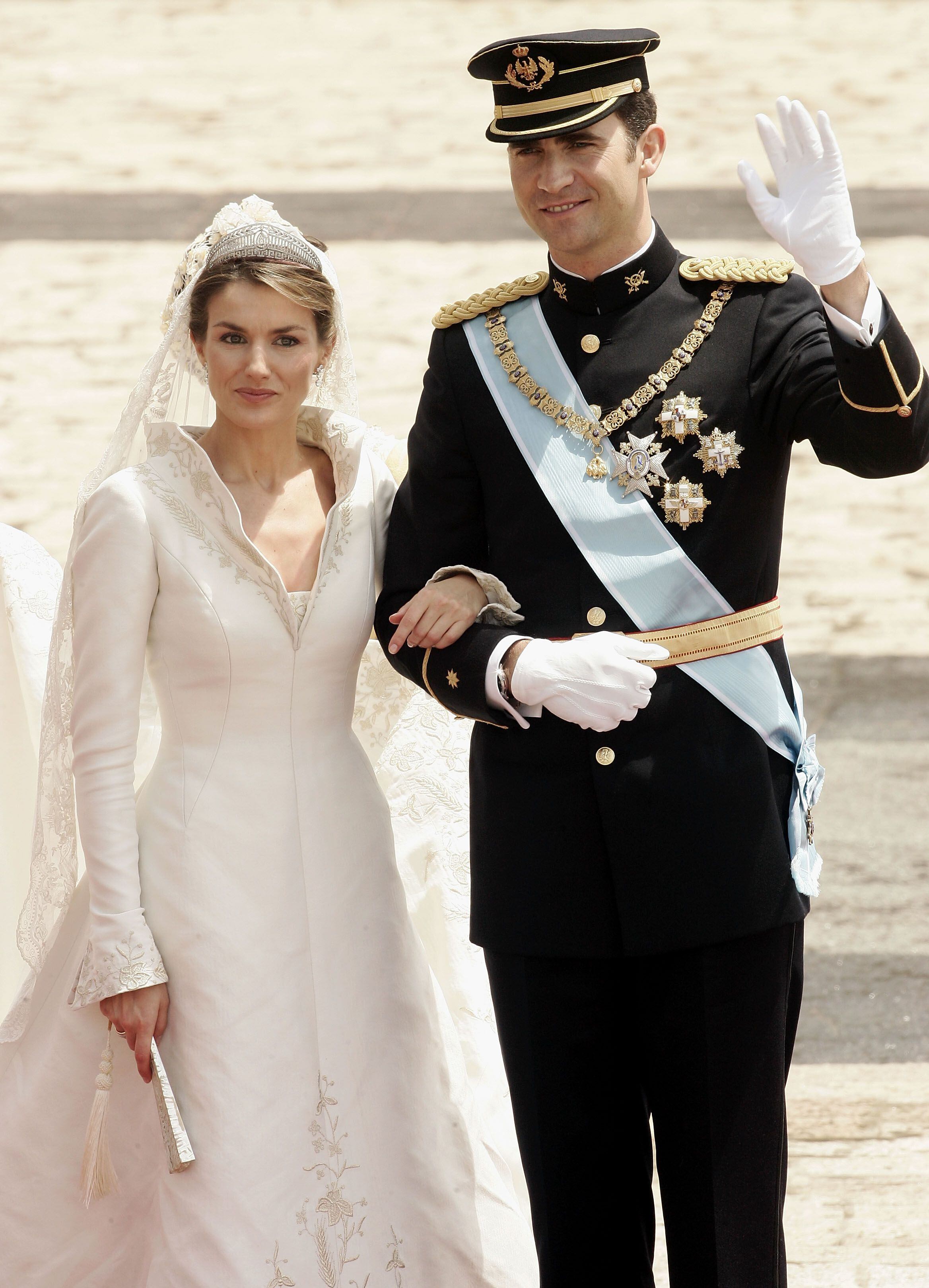 Los hoy reyes Felipe y Letizia, en el patio del Palacio Real después de su ceremonia de boda en la catedral de la Almudena, el 22 de mayo de 2004 en Madrid. Ella luce un abanico de nácar y encaje de Bruselas restaurado en Casa de Diego.