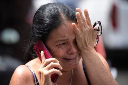 Una mujer llora mientras habla por teléfono frente a la cárcel de Tuluá.