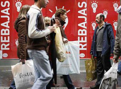 Un grupo de sevillanos pasea por la calle Tetuán cargados con bolsas en el primer día de las rebajas.