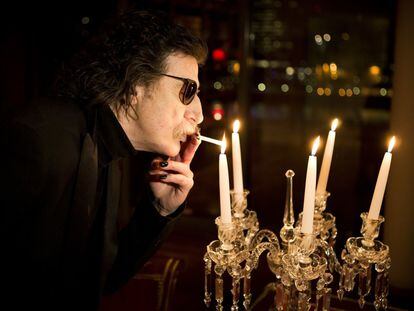 Charly García enciende un cigarrillo con la llama de una vela antes de una entrevista en Buenos Aires, Argentina, en 2013.