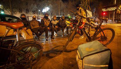 Un grup de 'riders' esperen les comandes al carrer, a Barcelona.