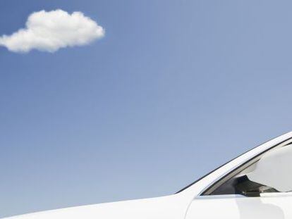  Un coche blanco bajo un cielo azul con una peque&ntilde;a nube blanca. 