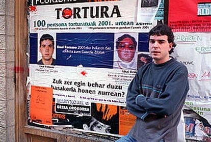 Unai Romano, en Vitoria, junto a uno de los carteles que denuncian las torturas que sufrió durante su detención.