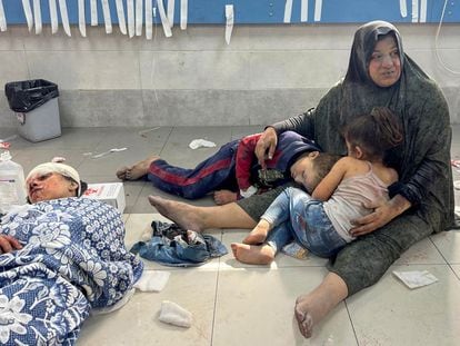 Una mujer abraza a sus dos hijos, heridos durante un bombardeo israelí, en el hospital de Shifa, en Ciudad de Gaza, el 23 de octubre.