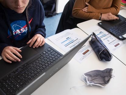 Dos alumnas utilizan ordenadores portátiles para un trabajo escolar.