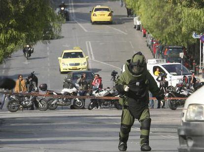 La policía griega corta la calle de Atenas donde se encuentra la oficina de mensajería en la que ha hecho explosión un paquete bomba dirigido a la Embajada de México.