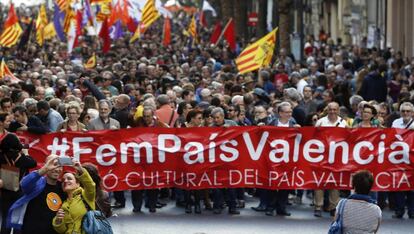 Una pareja se retrata ante la cabecera de la manifestación convocada por Acció Cultural del País Valencia (ACPV) con motivo del 25 d'Abril.