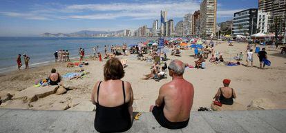 Una pareja de jubilados disfrutan del sol y las altas temperaturas en la playa de Levante en Benidorm, en Alicante. 