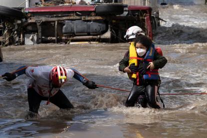 Una niña es auxiliada por rescatistas de la Cruz Roja debido a la orden de evacuación en la zona centro de Tula.