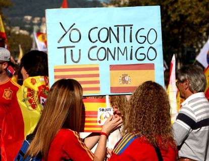 "Yo contigo. Tú conmigo", se lee en un cartel que portan unas participantes en la manifestación en Barcelona. Intelectuales y políticos catalanes han tomado la palabra al final de la marcha por la unidad de España.