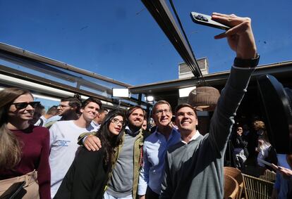 El presidente del PP, Alberto Núñez Feijóo, posa para una foto con jóvenes en un acto de vivienda en Madrid.