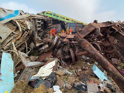 Miembros de los servicios de rescate trabajan este sábado entre los restos de los trenes accidentados el 2 de junio en la India.