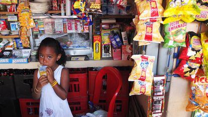 Una niña consume una bebida azucarada dentro de un negocio en Medellín, Colombia.