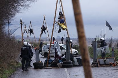 Activistas subidos a postes de madera esperan la acción de la policía alemana durante el desalojo, este miércoles.