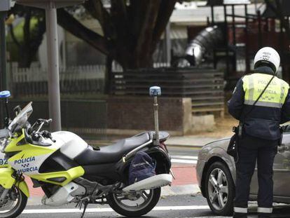 Un policía municipal de Murcia detiene a un vehículo que no cumple con el confinamiento decretado por el gobierno.