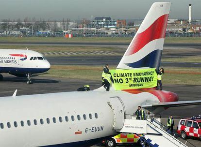 Activistas del grupo ecologista Greenpeace se suben a la cola de un avión en el aeropuerto de Heathrow para protestar contra la construcción de una tercera pista de aterrizaje.