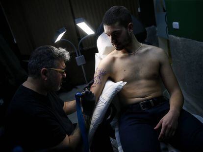 El tatuador Rasteu realiza un tatuaje en uno de los centros de tatuajes 