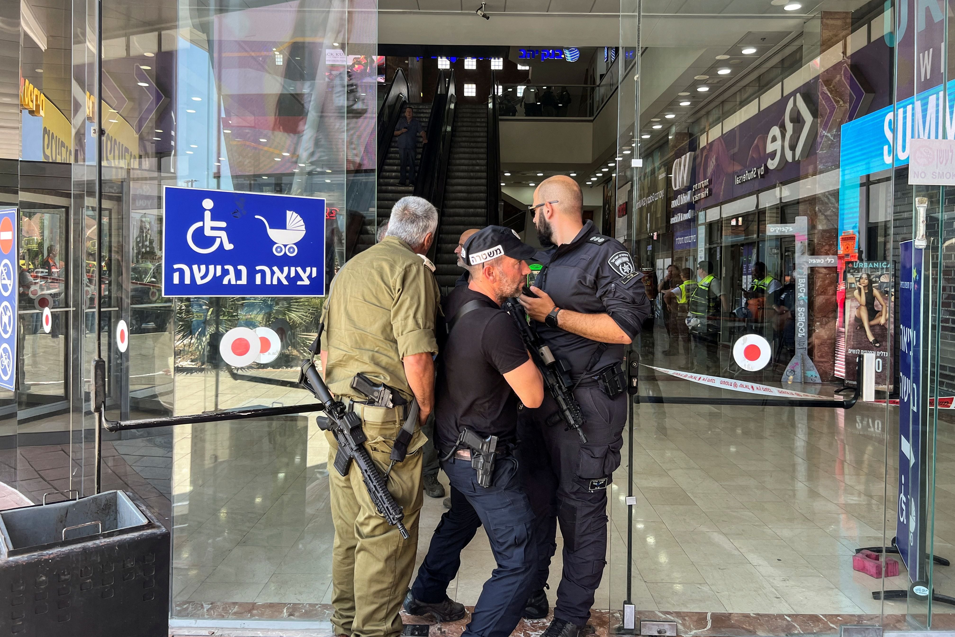 Israeli security personnel stand at the entrance to a shopping mall following a stabbing attack in Karmiel, northern Israel July 3 2024. REUTERS/Avi Ohayon