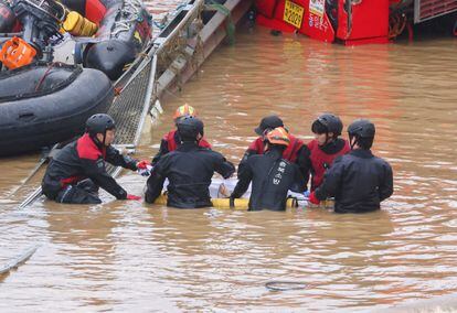 Los equipos de rescate llevan el cuerpo de una víctima encontrada durante las operaciones de salvamento en busca de sobrevivientes de la inundación.