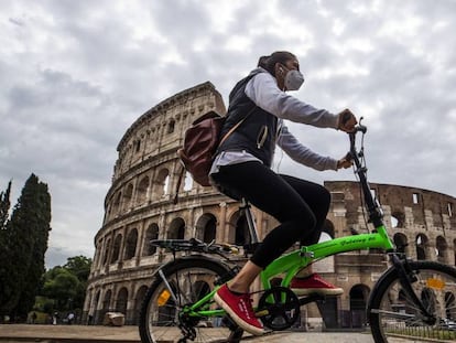 Una ciclista pasa frente al Coliseo romano.