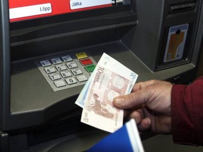 Un hombre retira euros de un cajero automático.