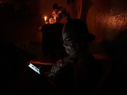 Una mujer revisa su celular en medio de un apagón en Tegucigalpa, Honduras, el 13 de junio.