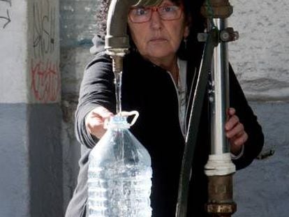 Una vecina de Vigo se abastece de agua potable en una fuente p&uacute;blica.