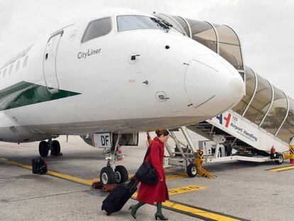 Una azafata embarca un avi&oacute;n de la aerol&iacute;nea italiana Alitalia en el aeropuerto de Mil&aacute;n.