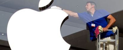 Un trabajador limpia el logotipo de Apple