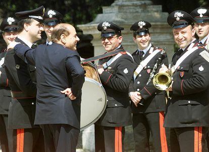 El primer ministro italiano Silvio Berlusconi, charla con la banda de Carabineros mientras espera la llegada del presicente checo en visita oficial en abril de 2002.