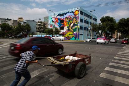 Un hombre intenta cruzar una avenida con una carretilla, en Ciudad de México, en una imagen de archivo.