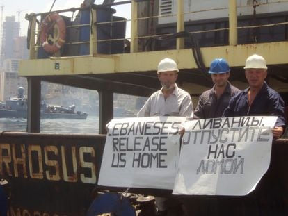El capitán del 'Rhosus', Boris Prokoshev, y miembros de su tripulación muestran pancartas pidiendo su liberación en la embarcación que portaba 2.750 toneladas de nitrato de amonio, en el puerto de Beirut, en 2014.