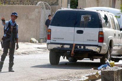 Un soldado iraquí vigila la zona en la que han sido atacados un grupo de diplomáticos rusos cuando viajaban en su vehículo (en la imagen).