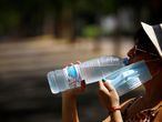 GRAF7930. CÓRDOBA, 01/08/2020.-Una mujer se hidrata para aliviar las altas temperaturas, hoy sábado Córdoba continúa en aviso naranja por altas temperaturas. EFE/Salas