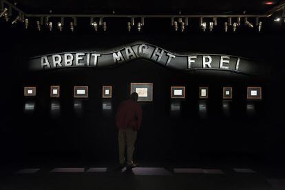 Una sala de la exposición, con el cartel de la entrada del campo de Auschwitz, en el que se lee "El trabajo os hará libres".