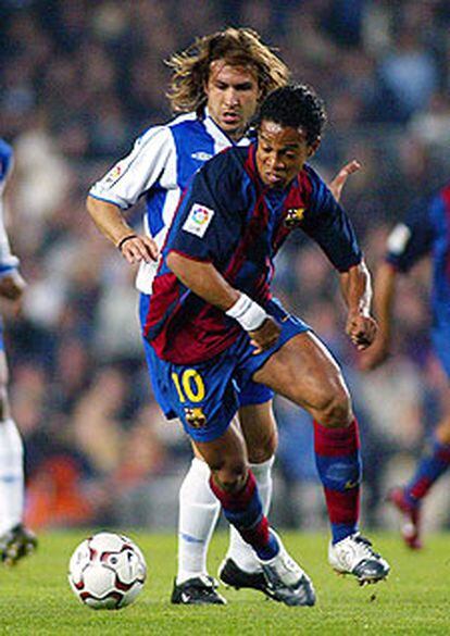 Ronaldinho se escapa del acoso de Àlex Fernández.