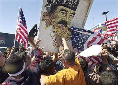 Miembros de la comunidad iraquí de Michigan golpean un retrato de Sadam en Dearborn, el pasado miércoles.
