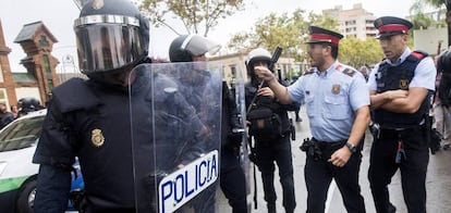 Agents antiavalots de la Policia Nacional i dels Mossos d'Esquadra discuteixen davant de l'Institut Can Vilumara de l'Hospitalet de Llobregat.