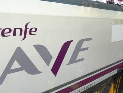Trabajos de rotulación sobre un tren de alta velocidad con el nuevo logotipo del AVE de Renfe.