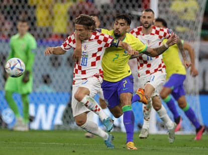 Luka Modric (izquierda) de Croacia, disputando un balón con Lucas Paqueta de Brasil, en el partido de cuartos de final entre Brasil y Croacia. 