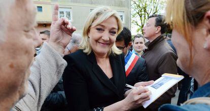 La candidata del Frente Nacional a la presidencia francesa, Marine Le Pen firma aut&oacute;grafos hoy frente a una exoficina de la Gendarmeria en Brienon-sur-Armanon, en el dentro de Francia.