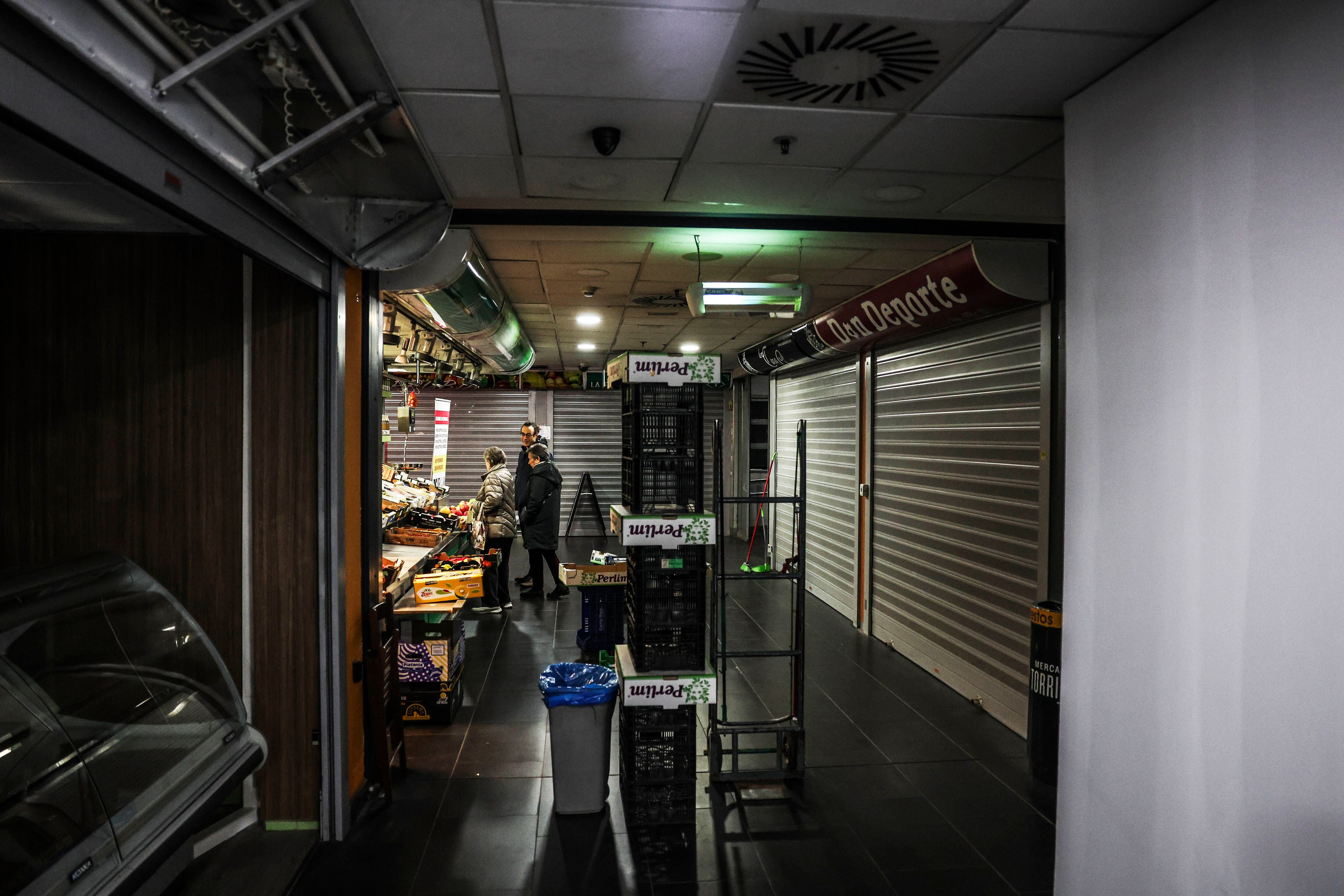El interior del mercado de Torrijos, este lunes en Madrid, con los puestos que quedan ocupados y la parte que fue tapiada este fin de semana.