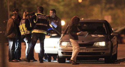 Unos policías inspeccionan el vehículo en el que murió Óscar Fernández.