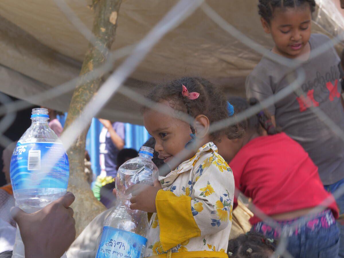 Varios niños reciben agua en la frontera entre Etiopía y Sudán.