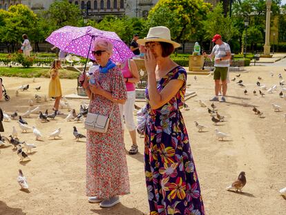 Una turista con paraguas el parque de Maria Luisa este domingo, en el primer día de la ola de calor.