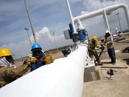 Trabajadores en Manaure (Colombia) ajustan una válvula del gasoducto que conecta con Venezuela, en 2007, un día antes de su inauguración.