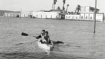 Tres personas navegan en piragua por la sevilla inundada de 1961.